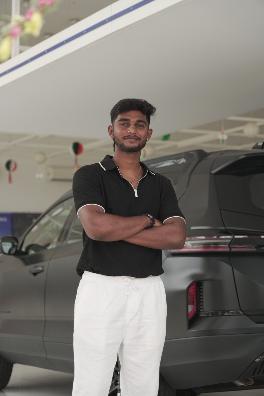 Raya standing beside a car