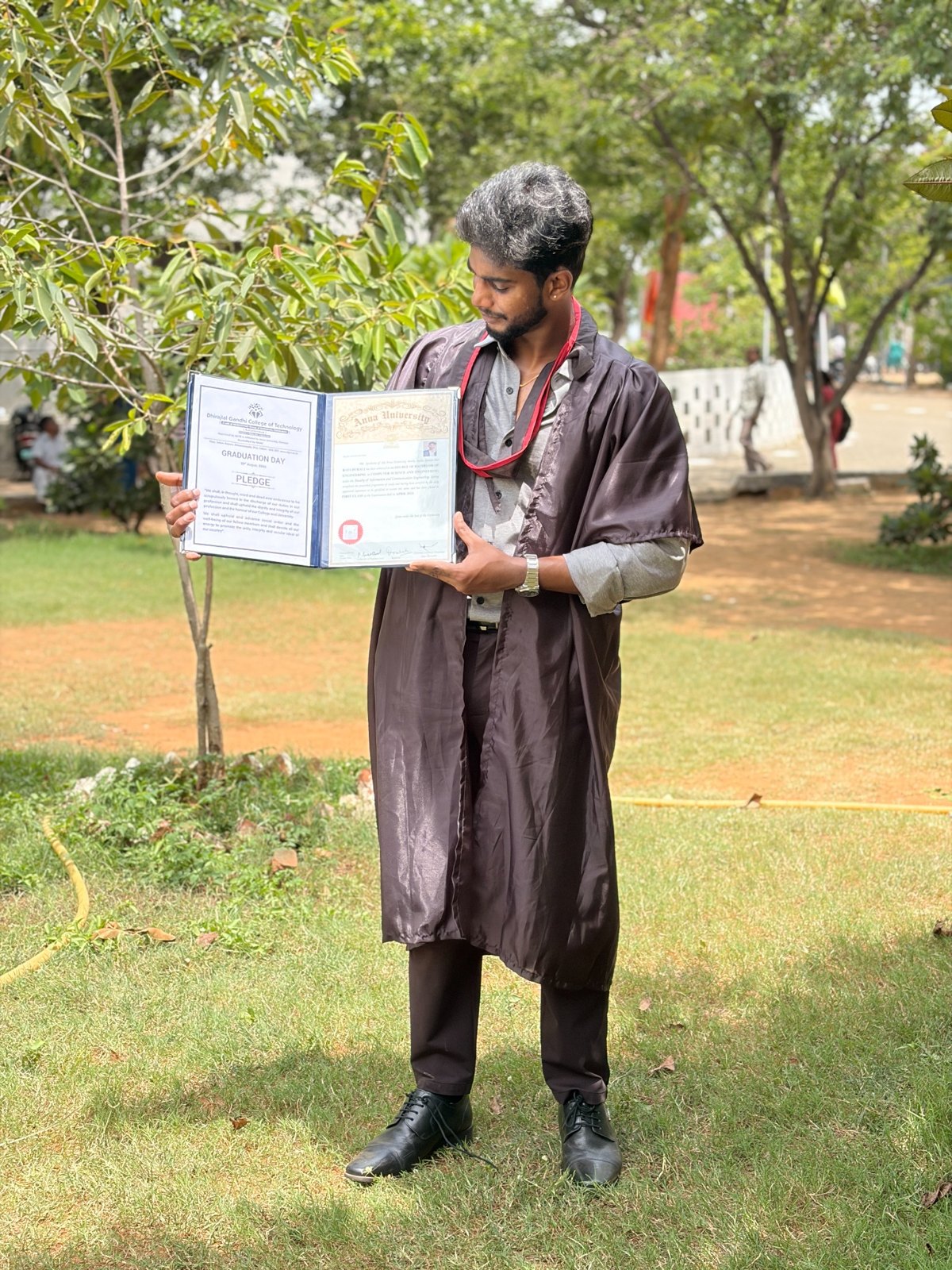 Raya holding his engineering graduation certificates